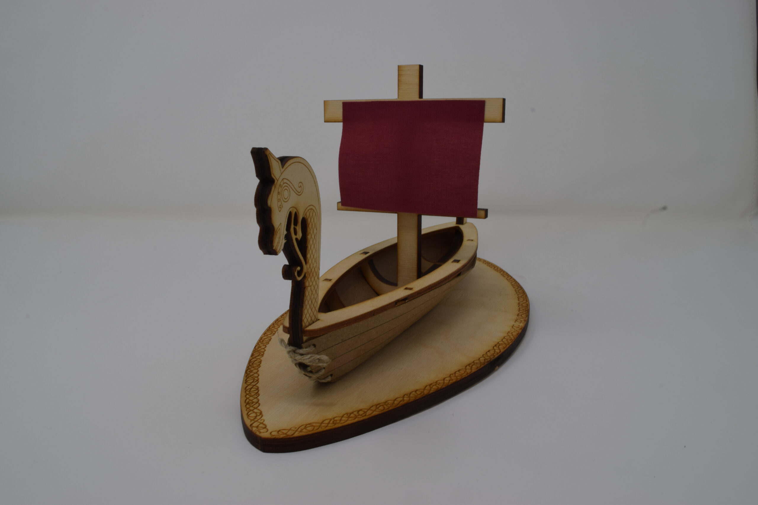 Photo of a lasercut sculpture of a viking longboat, relatively head-on angle.