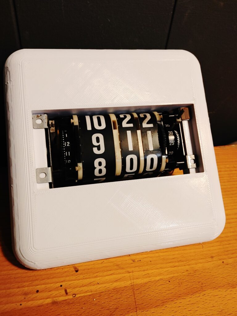 Left profile view of a 3D printed faceplate with an analog clock timepiece sitting inside it.